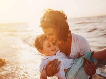 mother carrying sun on beach